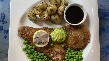 Klassisk Wienerschnitzel Gödkalv Schnitzel Serveras Med Stekt Potatis, Kapris, Ansjovissmör Och Rödvinsås